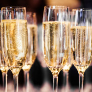 Meerdere gevulde champagne glazen op een donkere achtergrond.
