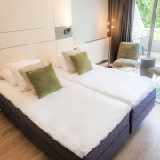 Classic Twin Room de l'hôtel spa de Limburg avec lit, coin salon et terrasse privée.