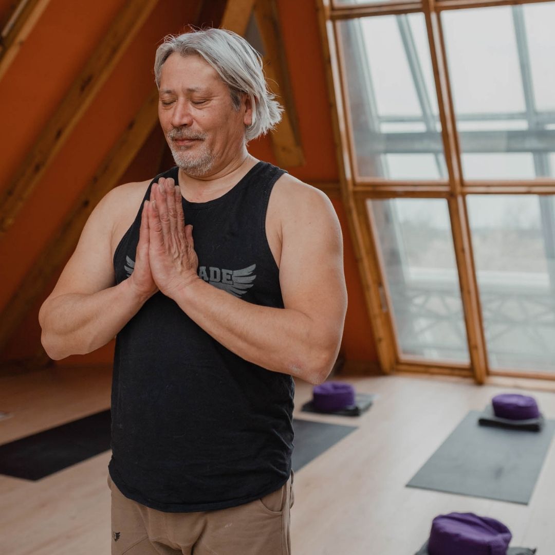 Man in Yoga positie in de punt van de wellness piramide.