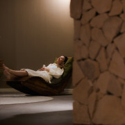 Femme en peignoir allongée sur une chaise de relaxation dans la salle de repos en marne de Thermae 2000.