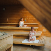Deux dames assises confortablement sur les bancs d'un sauna panoramique