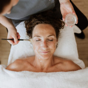 Femme profitant d’un soin du visage prodigué par un employé du spa de Thermae 2000.